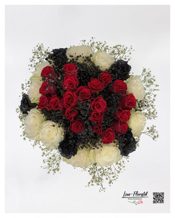 An artistic 40th bouquet of red, white and black roses, framed by delicate white gypsophila.