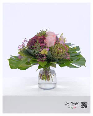 Gentle summer bouquet with hydrangeas, artichokes, pink roses, red gypsophila and lisianthus in pastel