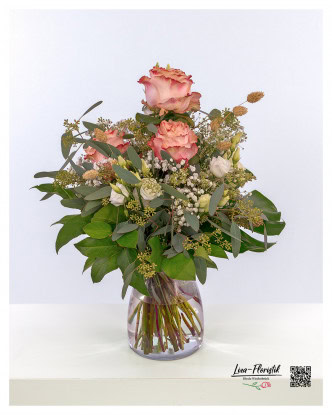 Elegant bouquet of flowers with pink roses, eucalyptus, gypsophila, phalaris and fresh monstera and salal leaves - a harmonious composition for special moments.