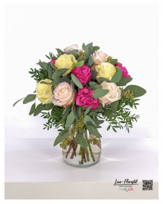 Rose composition in soft pastel tones and strong pink. This rose bouquet combines delicate cream and pink tones with bright pink, accented by fresh eucalyptus and greenery. A stylish arrangement in a glass vase that will brighten up any room.