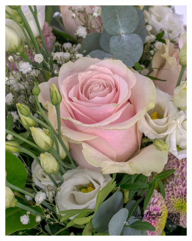 Delicate elegance: Pink rose surrounded by lisianthus, gypsophila and eucalyptus - a perfect interplay of natural beauty