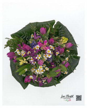 The spring bouquet of bright purple tulips, bright white chamomile flowers, fragrant hyacinths, light yellow daffodils and delicate green leaves appears particularly harmonious and lively from a different perspective.