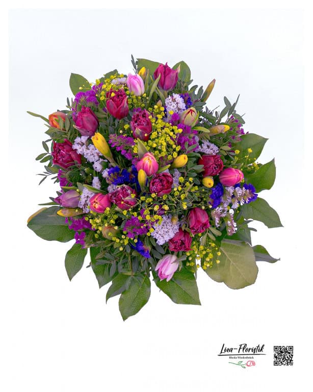 A colorful spring bouquet with a harmonious mix of tulips, delicate flowers and fresh greenery - vividly arranged for a natural and elegant look.