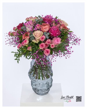 Lush, round bouquet of roses in various shades of pink and pink, lovingly combined with delicate pink gypsophila, subtle eucalyptus branches and fresh leafy greens.