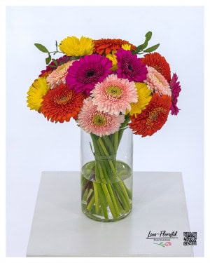 Colorful bouquet with Gerbera in strong colors such as pink, orange, yellow and delicate pink, lovingly tied in a round shape and complemented with green.