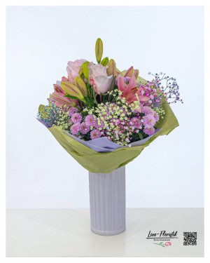 Happy birthday bouquet with pink lilies, delicate roses, purple chrysanthemums, gypsophila and colored statice - lovingly tied and wrapped with a decorative green-purple paper cuff, perfect as a flowery birthday greeting.