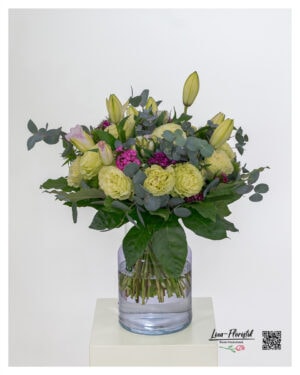 Exclusive bouquet of flowers with light green Ecuador roses, pink double lilies, bearded carnations in strong purple and fresh eucalyptus - tied round with elegant, dark green foliage.
