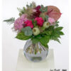 Modern bouquet with pink roses, pink hydrangeas, anthurium, poppy seed capsules, carnations, red ammi, eucalyptus and various types of greenery - lavishly arranged.