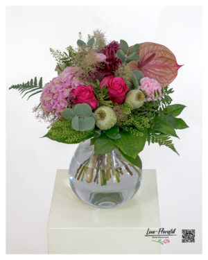 Modern bouquet with pink roses, pink hydrangeas, anthurium, poppy seed capsules, carnations, red ammi, eucalyptus and various types of greenery - lavishly arranged.