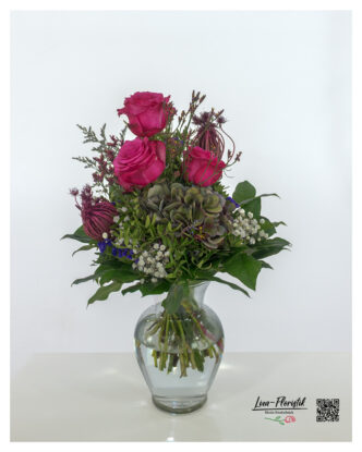 Stylishly tied bouquet of flowers with pink roses, green-purple hydrangea, white gypsophila, Ammi, violet statice and sea lavender - ideal for special occasions or as a high-quality floral gift.