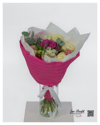 Bouquet with various roses, carnations, lisianthus, chamomile and eucalyptus, decoratively tied and arranged in a pink cuff.