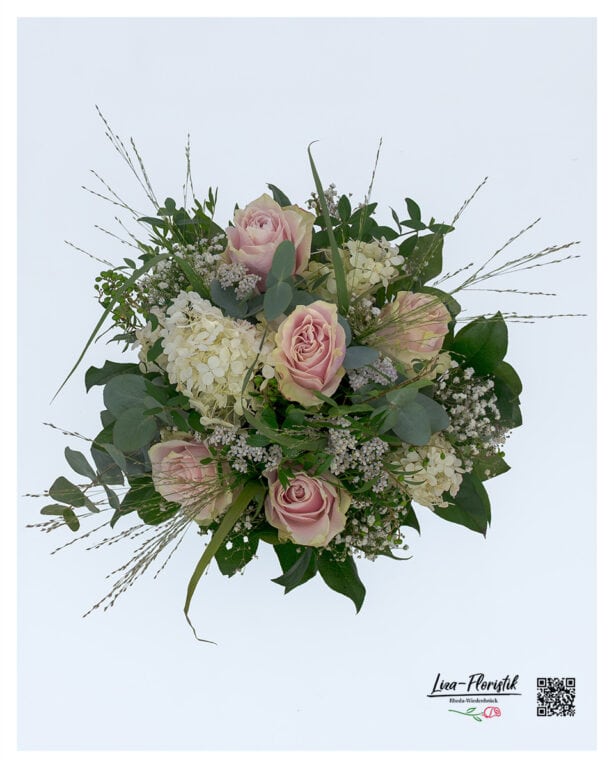 Lush bouquet top view with pink roses, cream hydrangea, delicate ornamental grass, white gypsophila and green privet berries