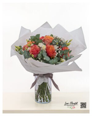 Apricot bouquet with roses and lisianthus in a warm coral tone, embedded in eucalyptus and gypsophila