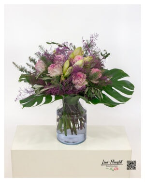 Lavish bouquet with pink roses, white amaryllis, monstera leaves, olive branches and lilac sea lavender
