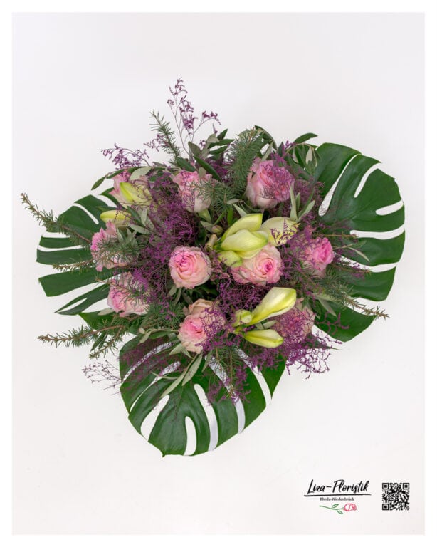 Close-up of white amaryllis and pink roses in a lush bouquet with green accents