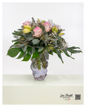 Delicate bouquet in shades of pink and cream, accented with lush greenery and subtle white details, loosely and elegantly arranged
