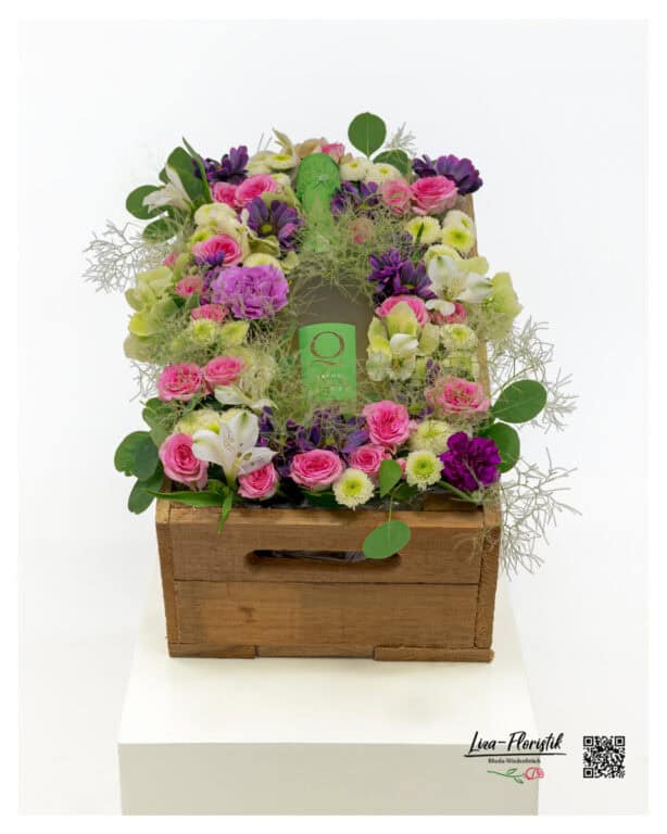 Janare Q Spumante as the centerpiece of an exclusive floral gift in a rustic wooden crate